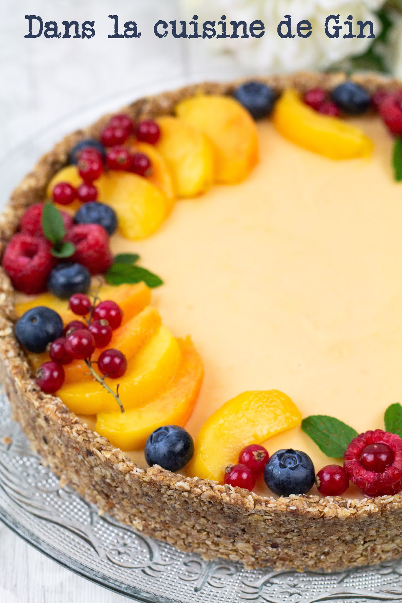 Tarte décorée de tranches de pêches et de fruits rouges